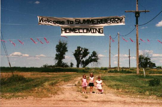 Image of kids standing under Welcome to Summerberry Homecoming sign